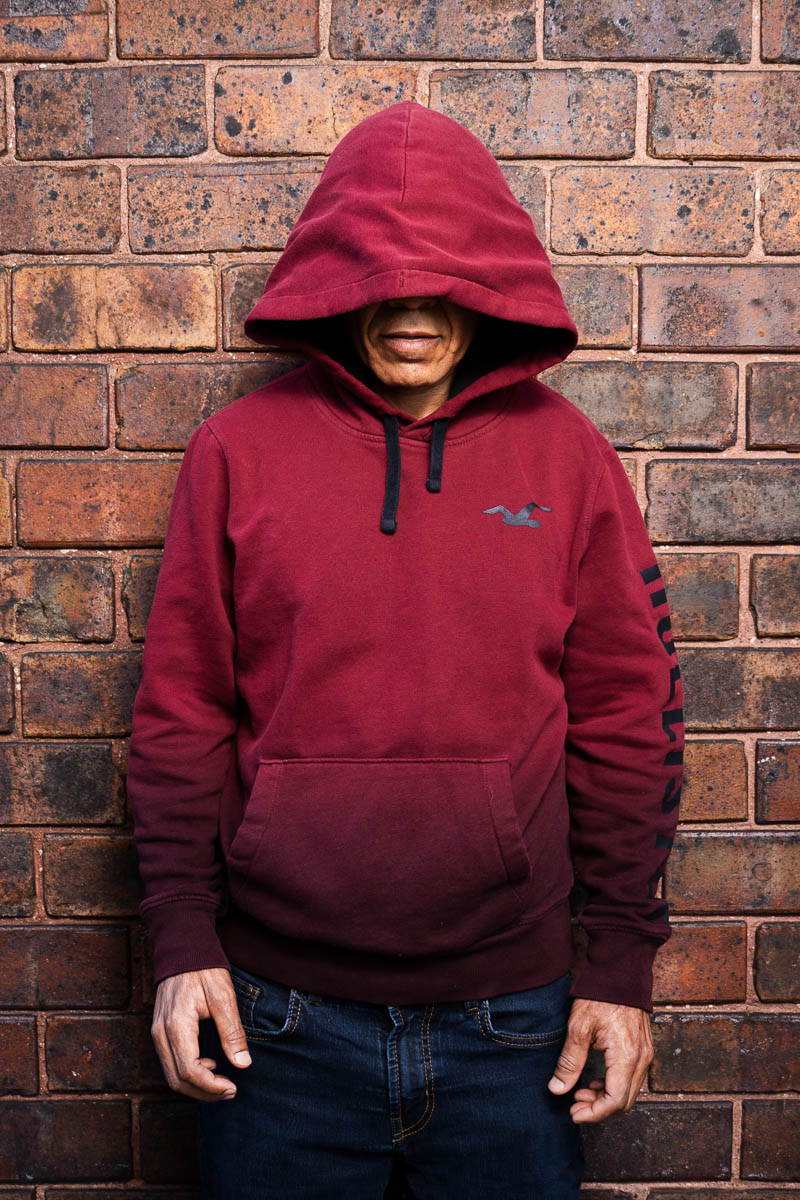 Portrait of Anthony, not showing his face and is wearing a red jacket hoodie.