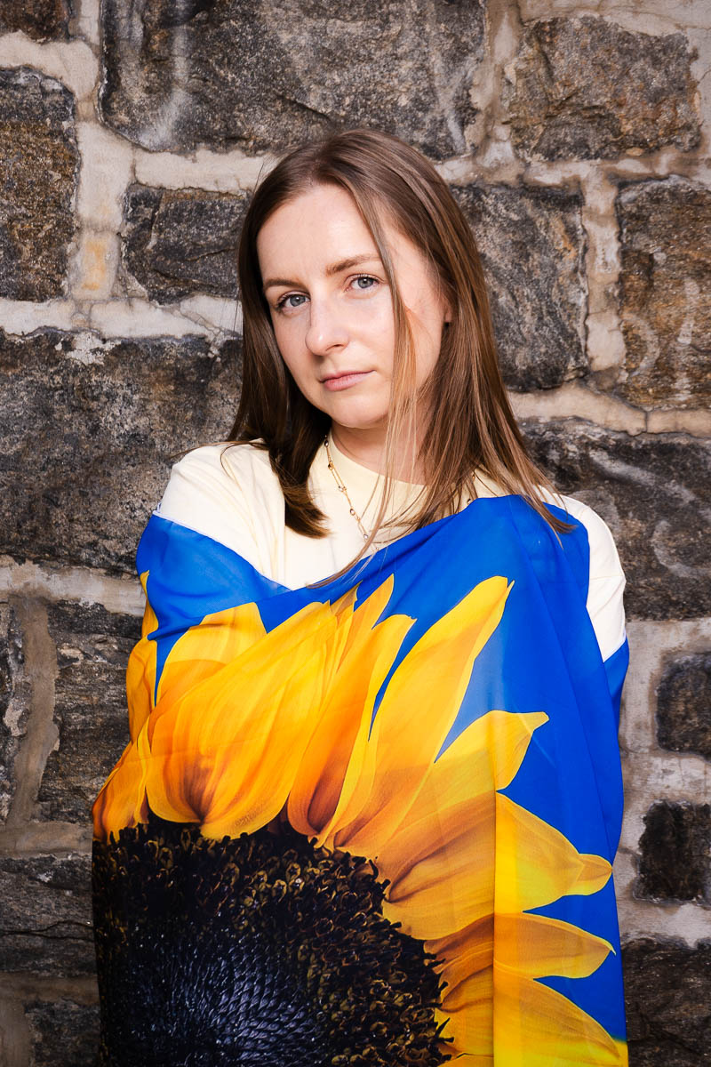 Portrait of Viktoriia, looking intently in the camera and wrapped a "flower" blanket around her