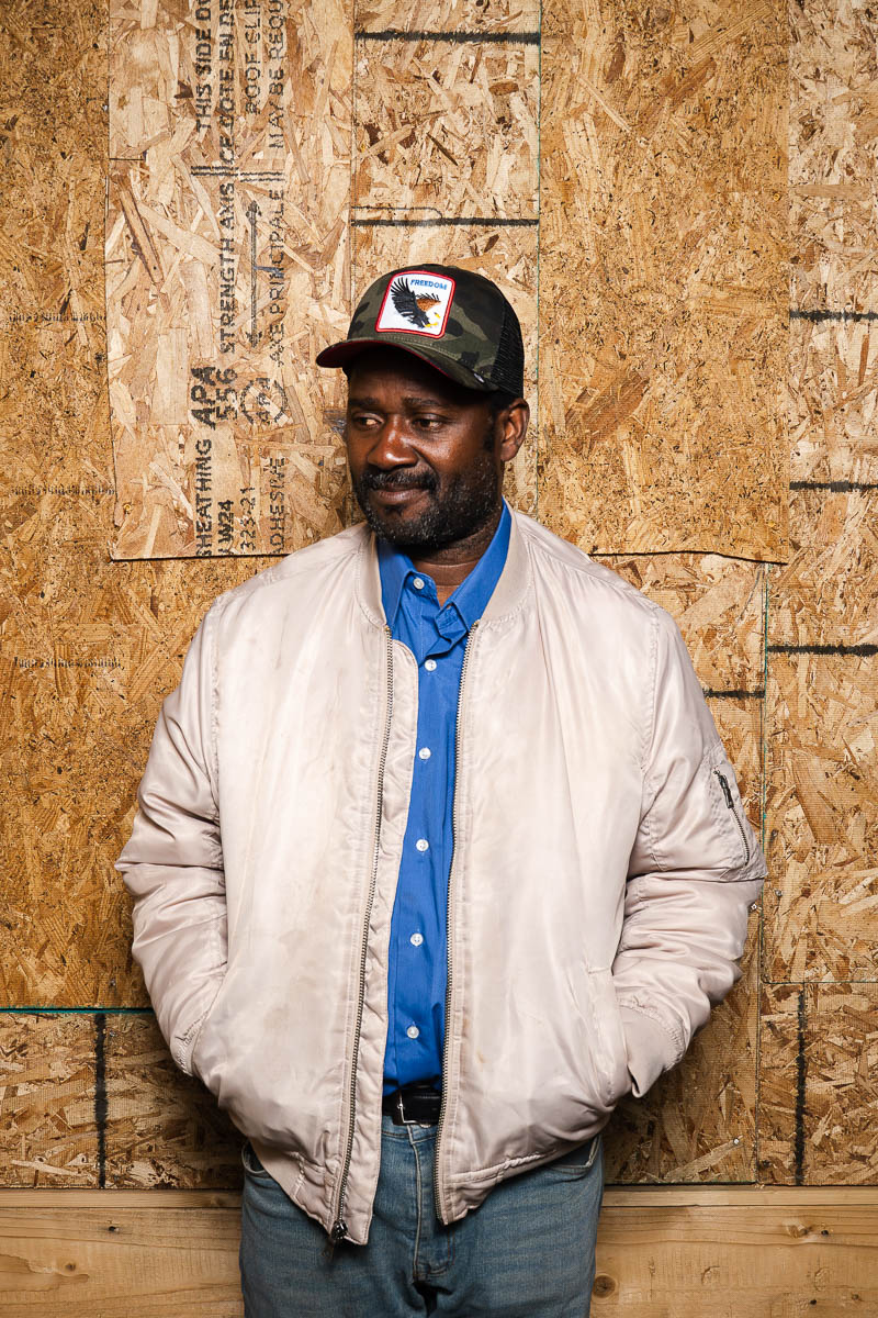 Portrait of Fred, wearing a white jacket with e blue shirt underneath.